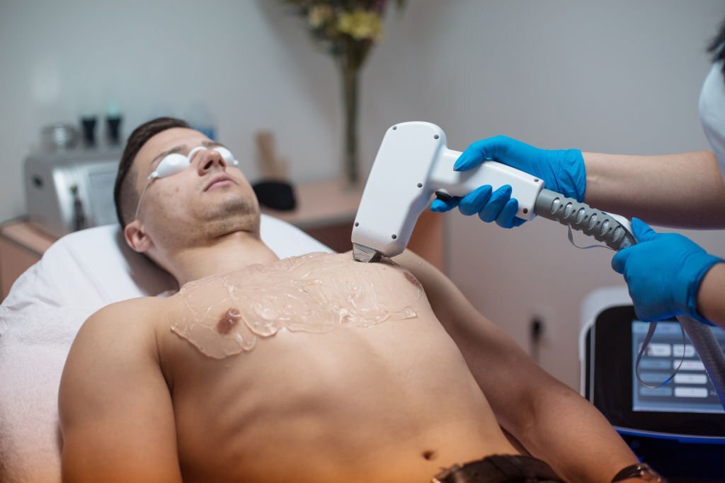 Man removing his chest hair with laser epilator